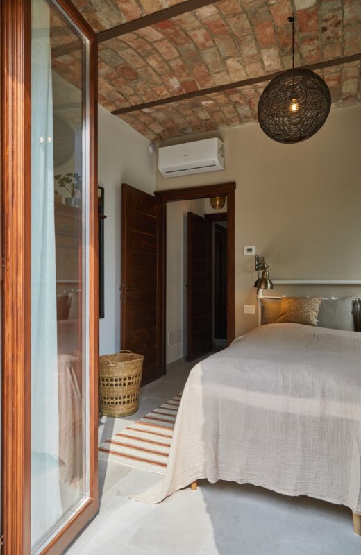 soveværels bage sandfarvet sengetæppe væg farvet unikt loft feriebolig overnatning i Italien ferie vacation