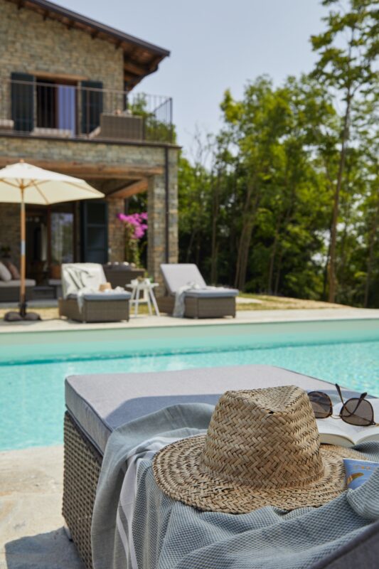 solhat på solseng solbriller ved infinity poolen luksus feriebolig ferie ferieinspiration nye oplevelser natur stenhus