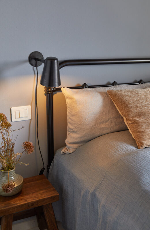 soveværelse interiør indretning farver blå væg pudder sengetæppe blomster sengelampe metalramme til seng overnatning værelse hjem