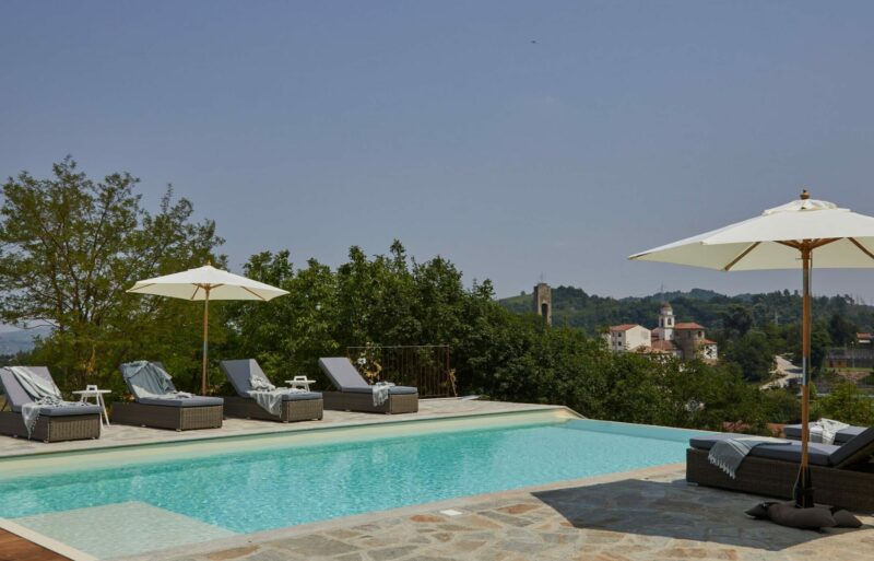 Pool solsenge udsigt over lille italiensk by infinity pool parasol