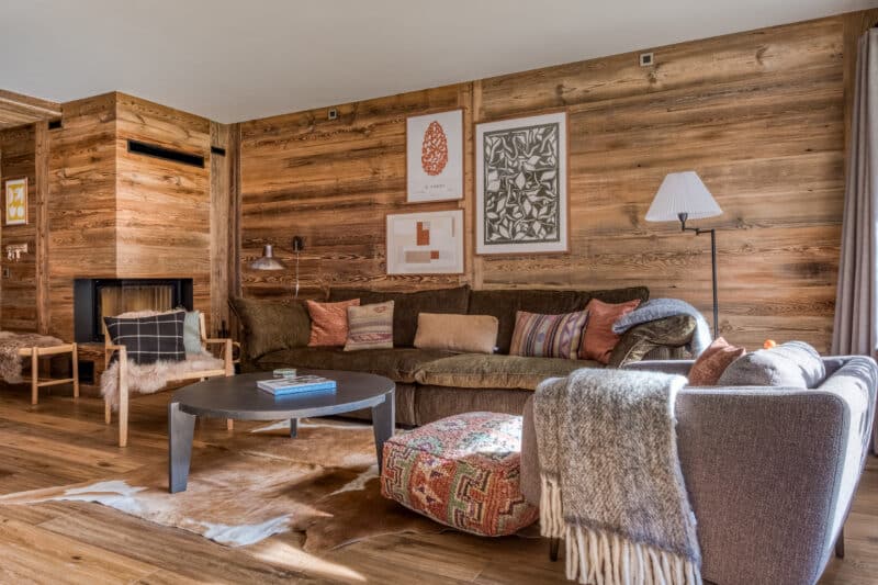 stue sofa pejs indretning interiør lænestol tæppe træ træhytte alperne bjergene